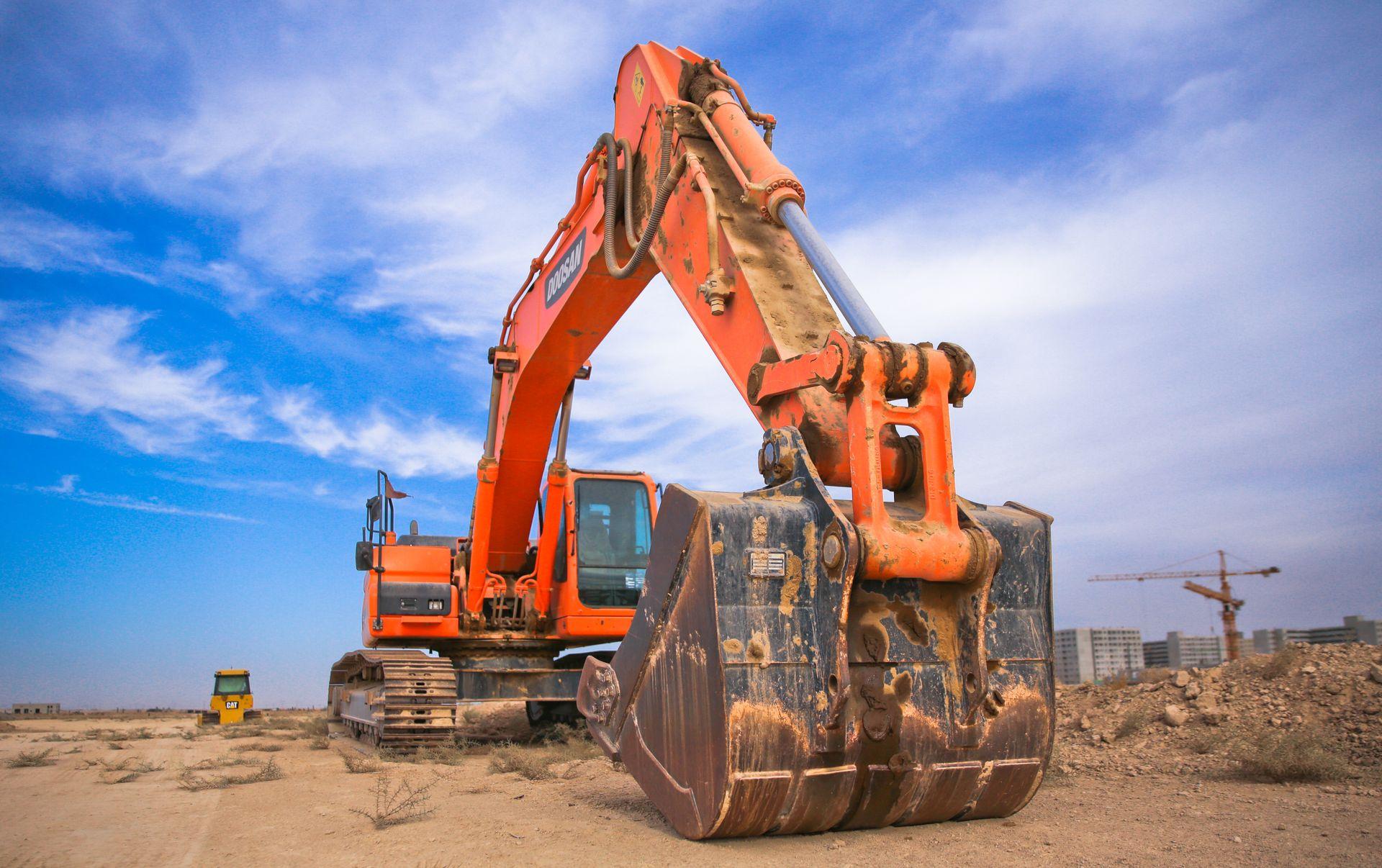 Orange excavator on a dusty construction site