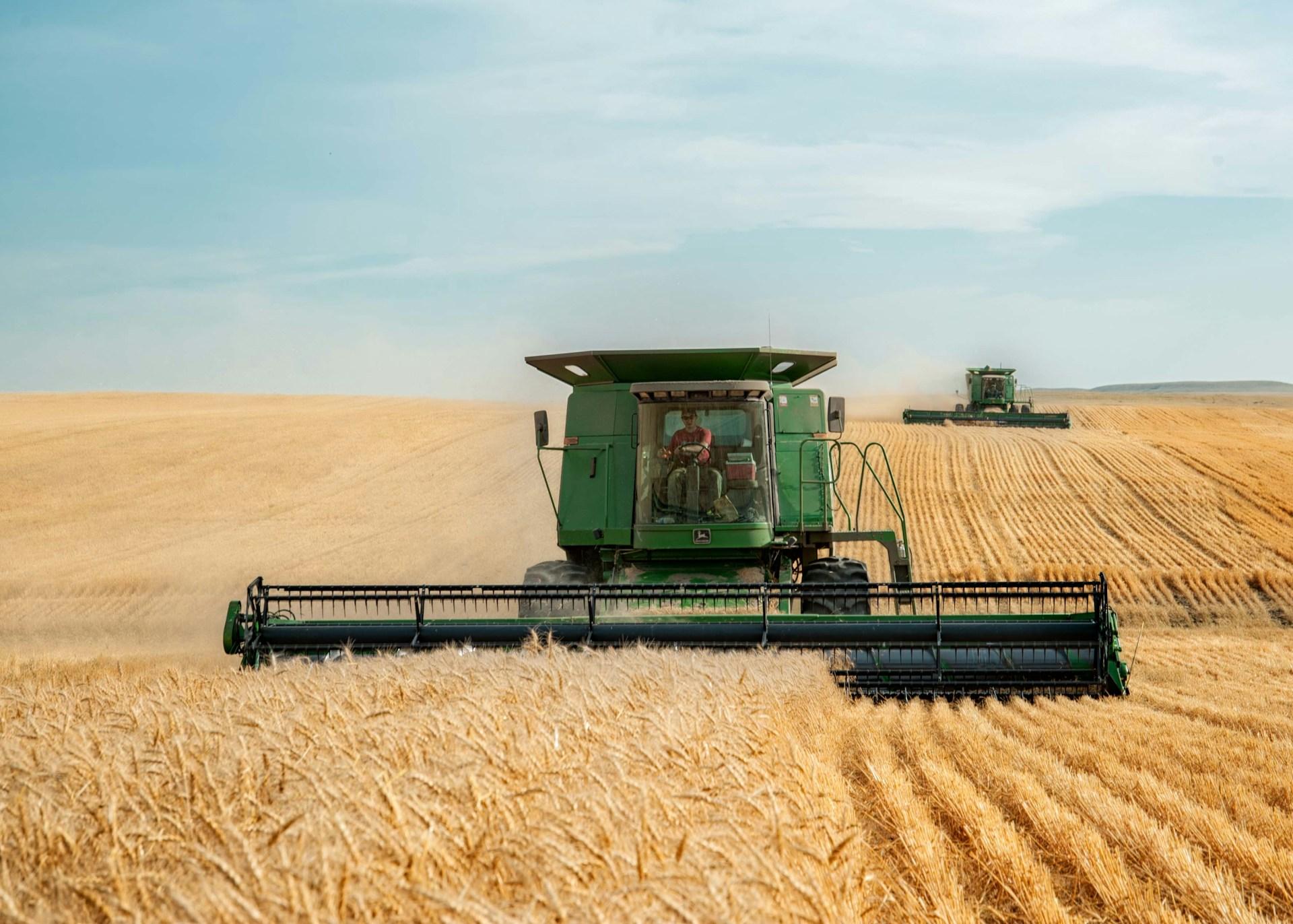 John Deere combines harvesting wheat in North Dakota
